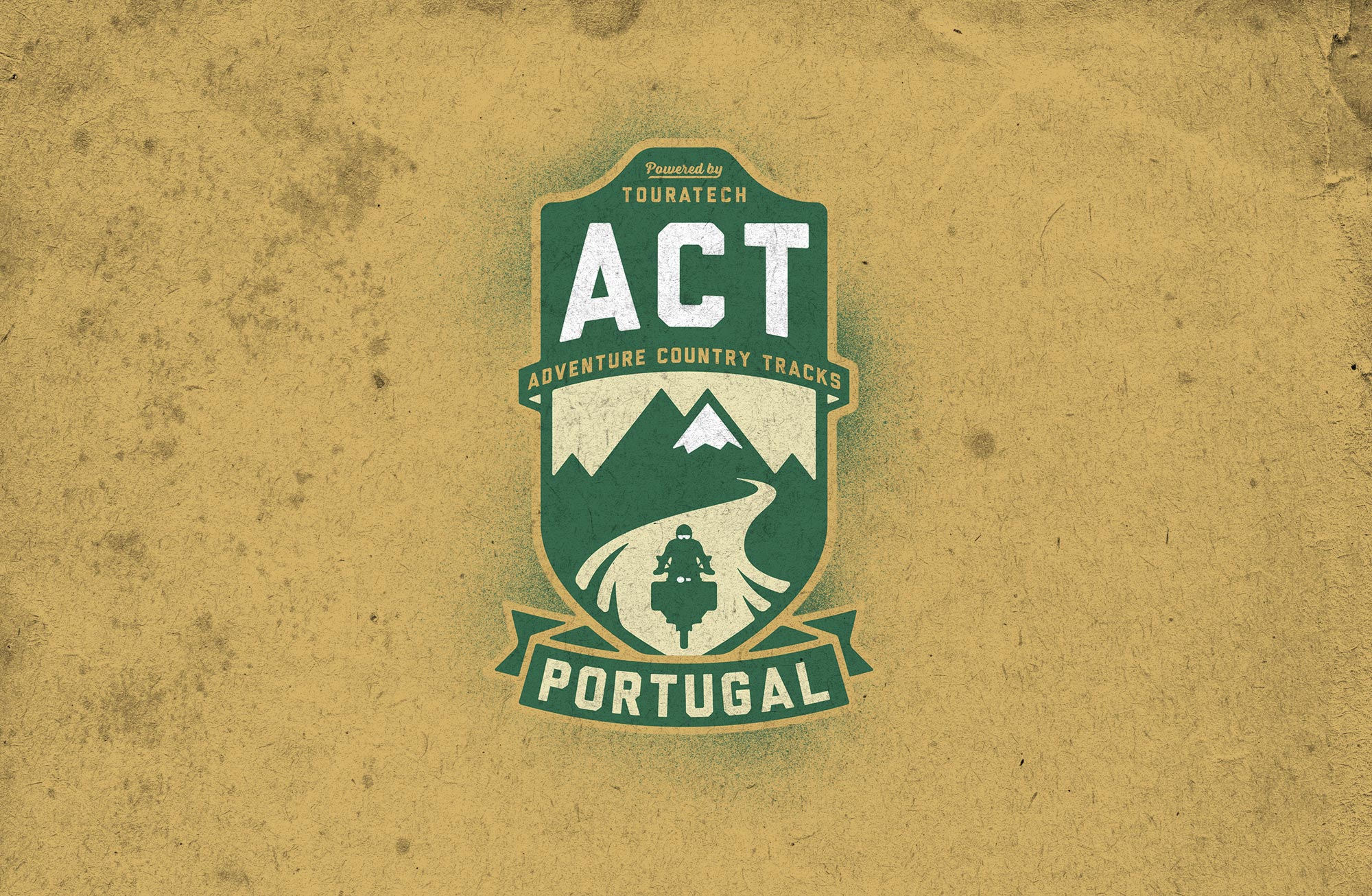 Man sieht das Logo der Adventure Country Tracks von TOURATECH. Das Logo hat eine Wappenform, oben sind die Buchstaben 