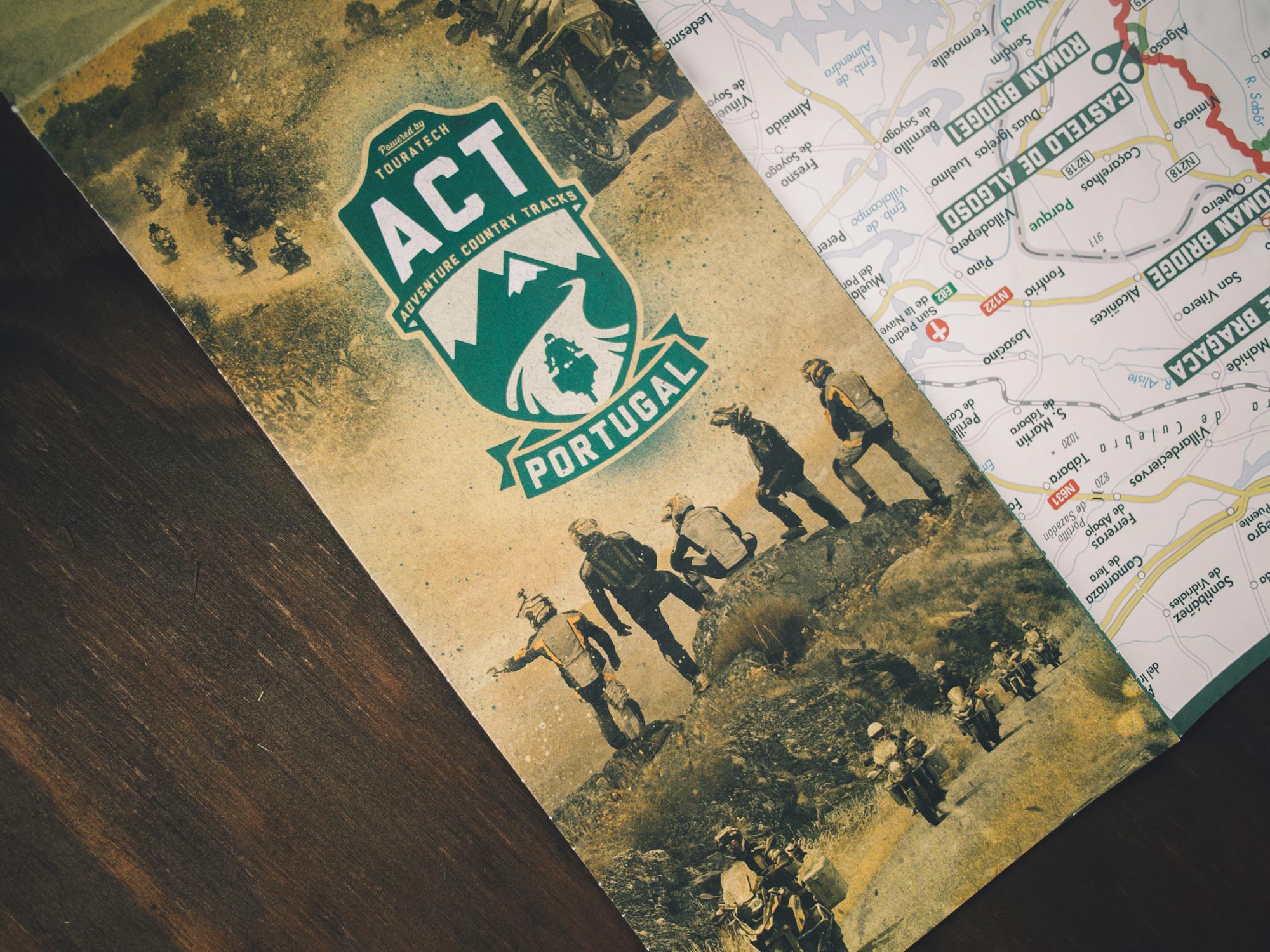 Man sieht das Foto der Straßenkarte zu den Adventure Country Tracks von TOURATECH, Version Portugal. Die Vorderseite dominiert das ACT-Logo, im Innenteil sieht man die Straßen-Karte. Das Corporate Design ist von MAJORMAJOR.